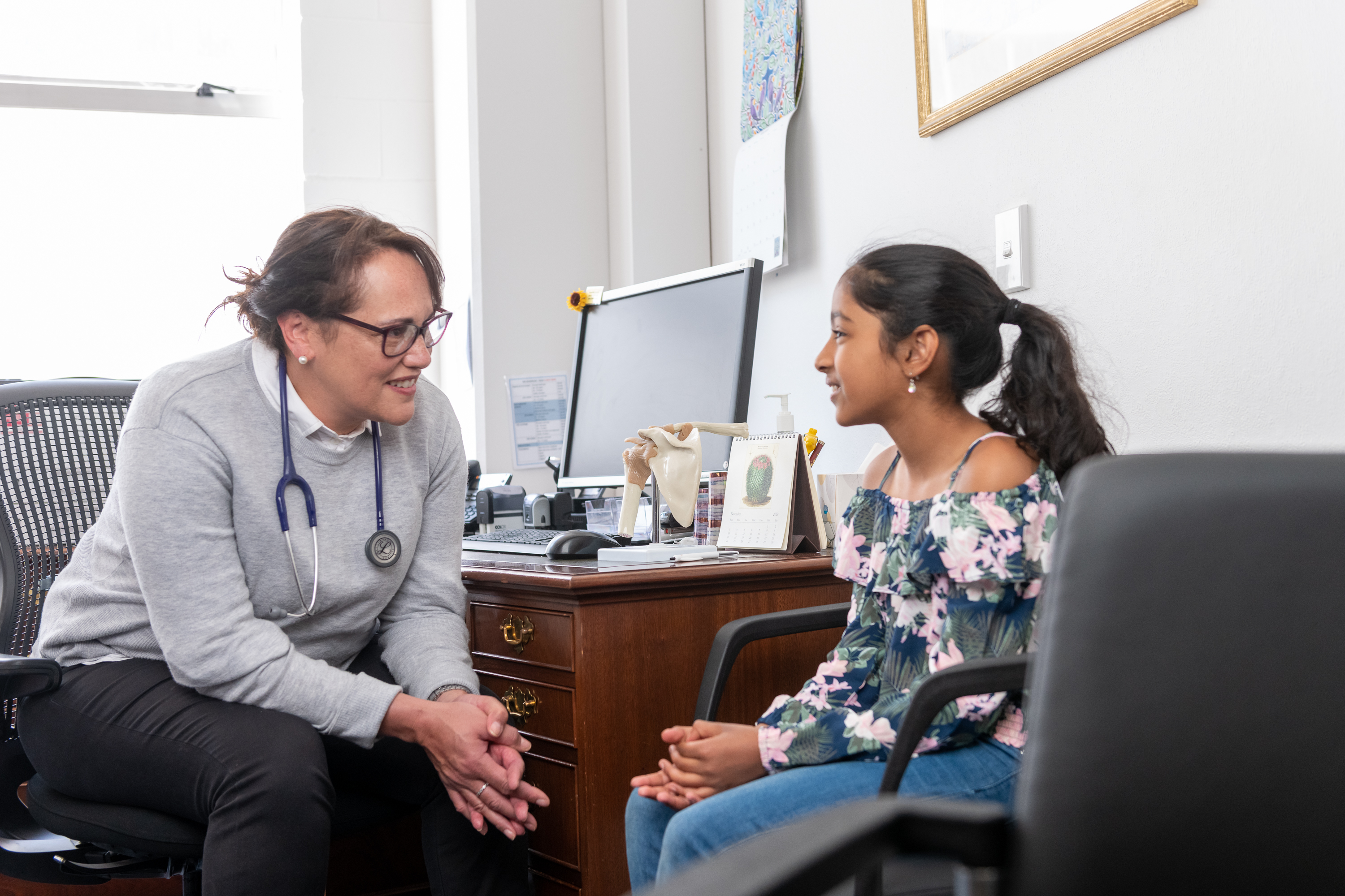 Health provider talking to young girl