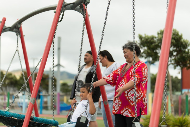 Grandmother pushing child on a swing