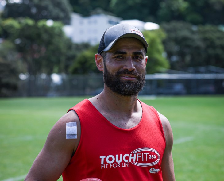 Alphonso smiles at the camera in his touch gear with a field in the background