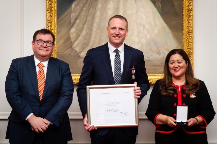 Andy Milne holds his award next to Deputy Prime Minister The Hon Grant Robertson, and Her Excellency