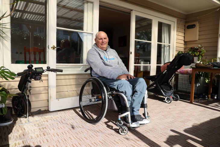 Brendan in his wheelchair on the porch of his property.