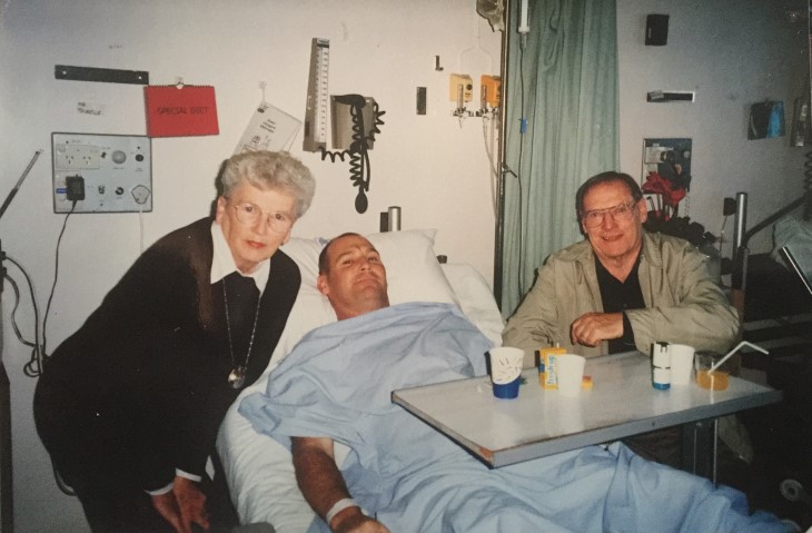Brendan on a hospital bed surrounded by family.