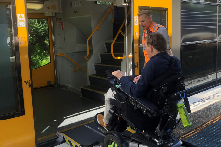 Dr Johnny Bourke using a wheelchair ramp to board a suburban Sydney train.