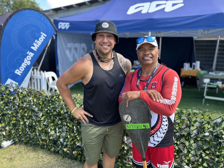 Rongoā practitioner Giovanni toI Mata standing with waka ama competitor Walter Togiamua, both are sm