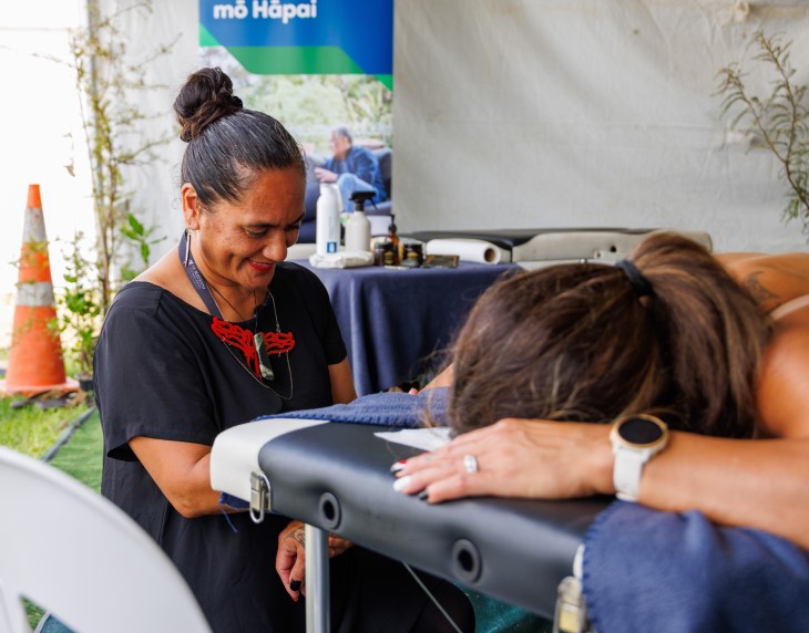 Practitioner Moana Skipwith-Lousi performing rongoā Māori on a woman at Te Matatini.