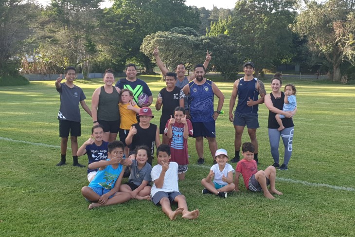 Extended family poses for a photo after playing touch together