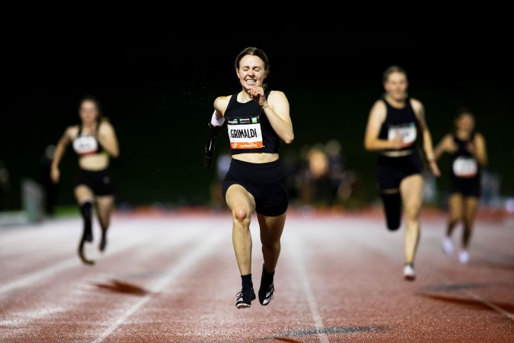 Anna Grimaldi sprinting down an athletics track towards the camera in a race.