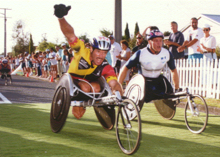 Ben Lucas raising his arm aloft during a wheelchair race.