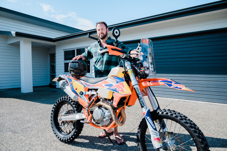 Blake Jones standing with his motorbike in the driveway of his house.