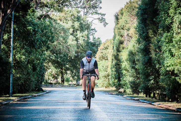 Blake Jones cycling along a road towards the camera.