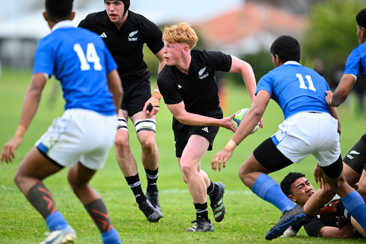 Charlie Sinton passing the ball during a game for the New Zealand secondary schools rugby team.