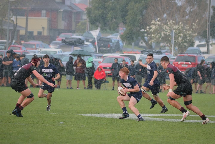 Charlie Sinton running with the ball during a school rugby game.