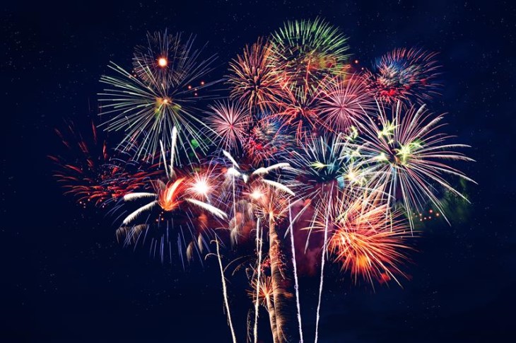 A wide-angle photo showing fireworks exploding in the night sky.