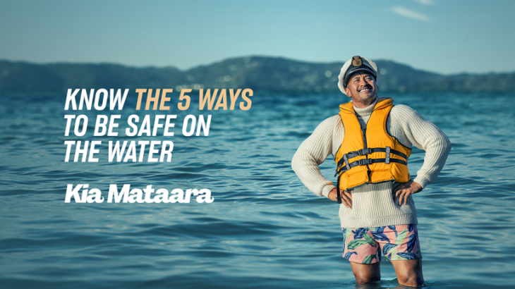 A man standing in the water wearing a lifejacket and a skipper's hat. Text on the photo reads, 'Know