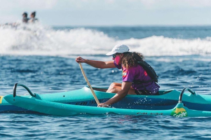 Hine Brooking paddling in her waka ama canoe on the water.