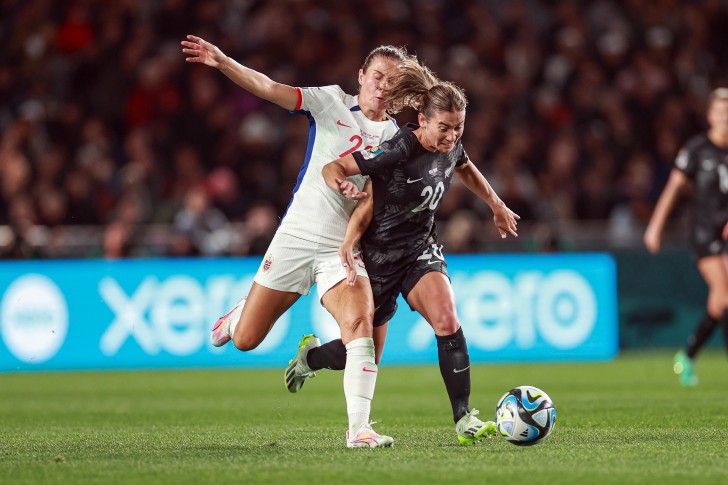 Indiah-Paige Riley runs past an opponent with the ball in a match for the Football Ferns.