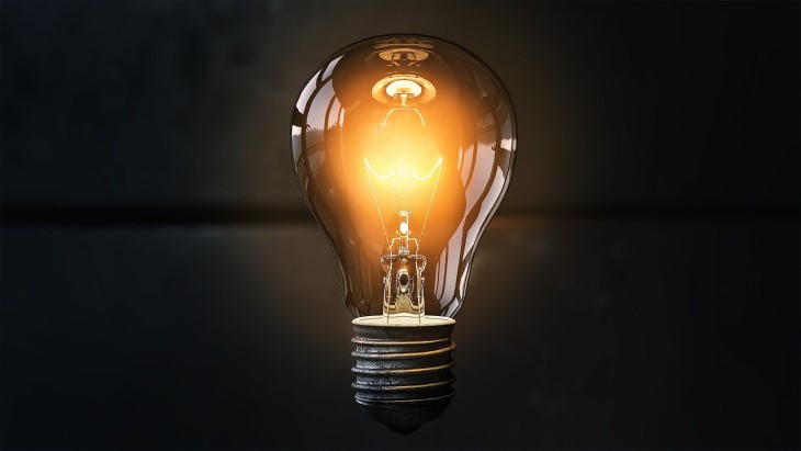 A photo of a light shining in a light bulb with a black background. 
