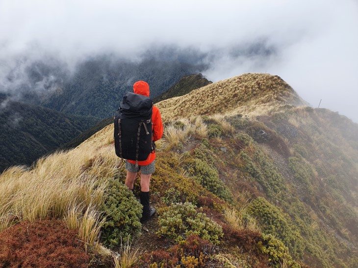 Liz Wightwick stands at the top of a ridgeline. 