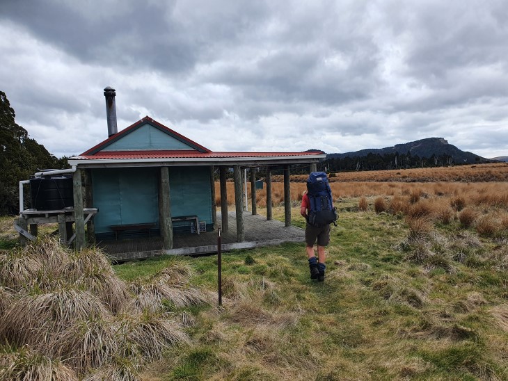 Liz Wightwick walks towards a tramping hut. 