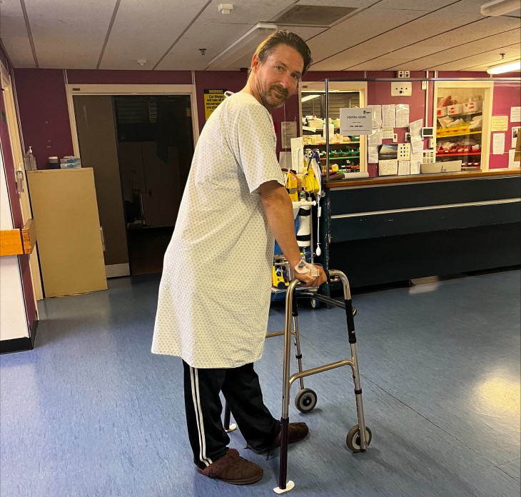Maz Quinn using a walking frame to walk in hospital. 