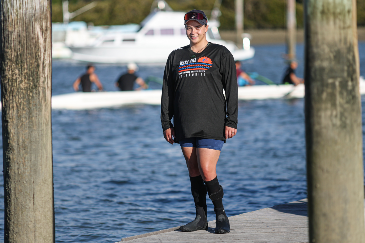 Peata Nuku standing on a wharf next to the water.