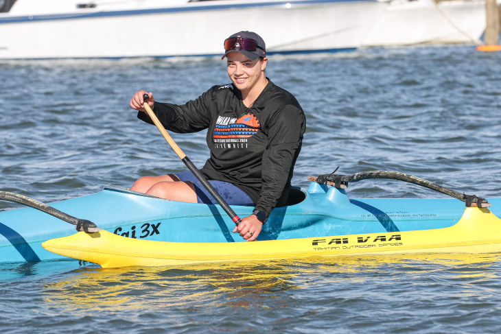 Peata Nuku paddling in her waka ama canoe on the water.