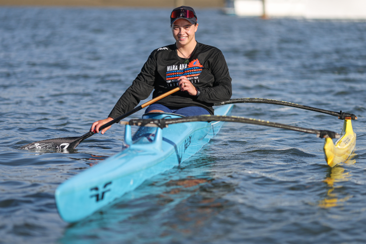 Peata Nuku paddling in her waka ama canoe on the water.