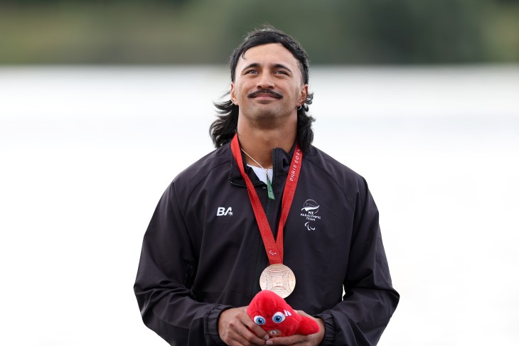 Pete Cowan standing on the Paralympics podium with his medal around his neck.