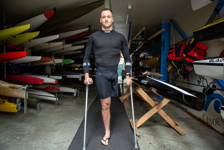 Scott Martlew standing in a boat shed on his crutches. 