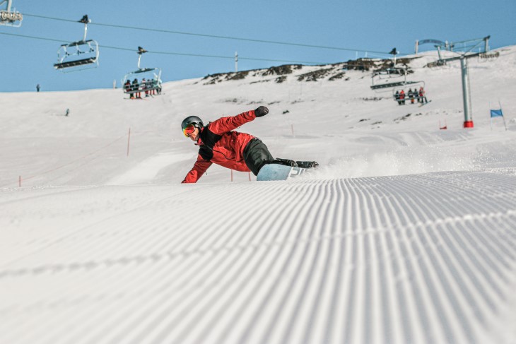 A snowboarder coming down a slope on a mountain.