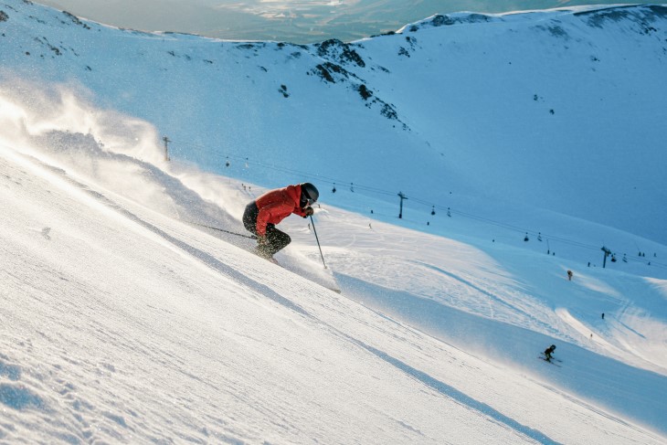 A skier coming down a slope on a mountain.