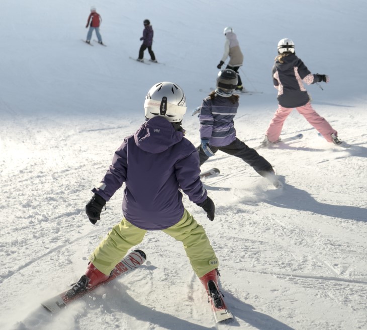 Several children learning how to ski.