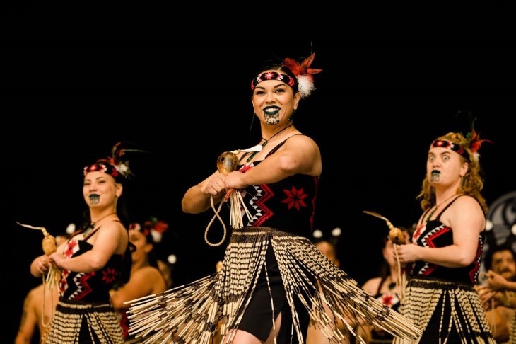 Several women wearing traditional Māori clothing and performing kapa haka.