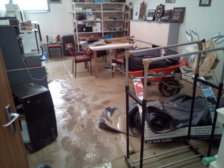 A photo showing damage in the Adventure Wairoa Sports Club shed, with silt covering the floor. 