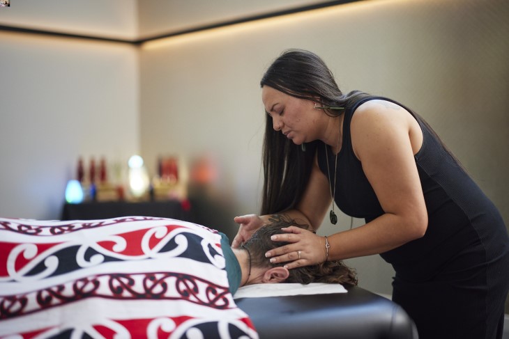 A rongoā Māori practitioner using her healing methods on a woman.