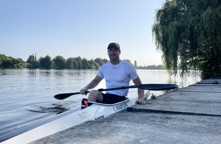 Scott Martlew sitting in his canoe on the water next to a jetty.